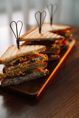 Different types of triangle sandwiches with skewers grilled on the table