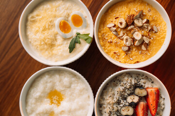 4 types of porridge in white bowls on a wooden background, oatmeal, corn, millet and rice