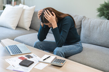 Financial owe asian woman sitting stressed by calculate expense at home, looking at invoice or bill, have no money to pay, mortgage or loan. Debt, bankruptcy or bankrupt concept