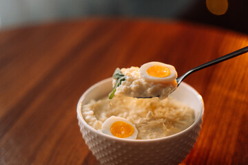 millet porridge with egg in a white bowl on a dark background