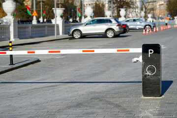 Modern parking barrier with visible impact damage and shattered glass, restricted vehicle entry point, vandalism. Damaged security barrier at lot entrance, accident impact or deliberate destruction