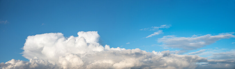 background overcasted with cumulus clouds, blue sky with copy space above