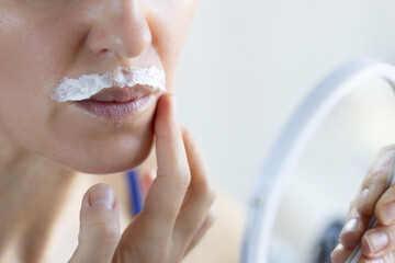 Depilation with depilatory cream mustache on female face.
