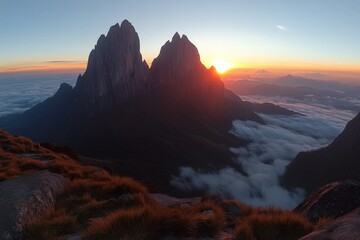 Majestic sunrise over mountain peaks shrouded in clouds in a tranquil landscape setting