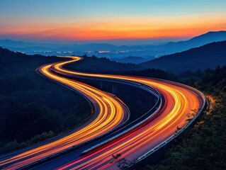 Winding Road at Twilight with Light Trails Through Mountains and Cityscape at Sunset Scenic View