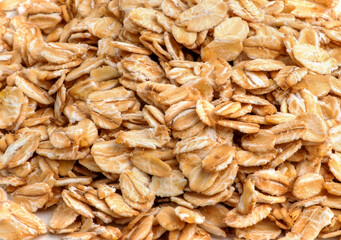 Rolled oat, oat flakes background or texture. Close up, directly above.