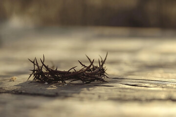 Fototapeta premium A crown of thorns lying on a weathered wooden surface in a softly lit, shallow depth of field scene