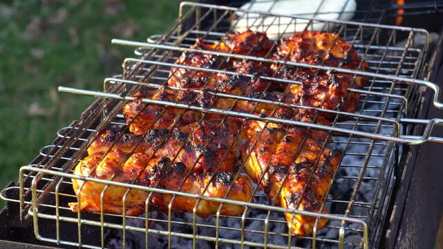 real time video of chicken legs and pita bread cooking in a grill grate above charcoal grill
