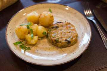 Squash burger with boiled potatoes on a plate