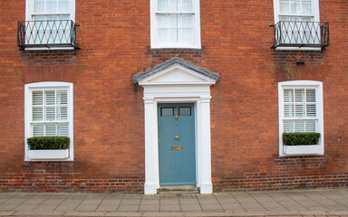 blue door with windows in brown building in England