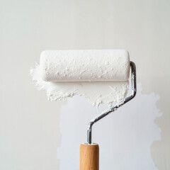 Obraz premium Close-up of paint roller applying white paint on wall, DIY home project