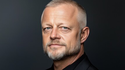 Obraz premium Confident man with a beard and short hair against a dark background
