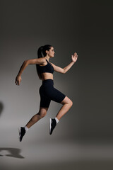 Dynamic sprint of a young athletic woman showcasing her fitness and determination in a sleek outfit
