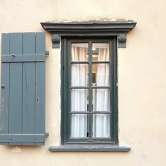 Obraz premium Graues Fenster mit weißen Vorhängen vor beiger Wand, ein Fensterladen halb offen. Die gedämpften Farben und der rustikale Stil schaffen eine charmante, antike Atmosphäre