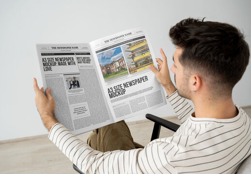 Mockup Of Man Reading Customized A3 Newspaper, Sitting