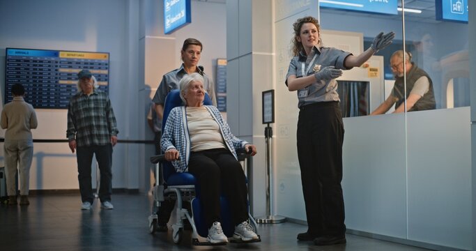 Security Checkpoint in Airport Terminal: Diverse Security Officers Inspecting Elderly Woman in Wheelchair and Elderly Man for Boarding Flight. TSA Screening Procedures. Senior Tourists Going on Trip.