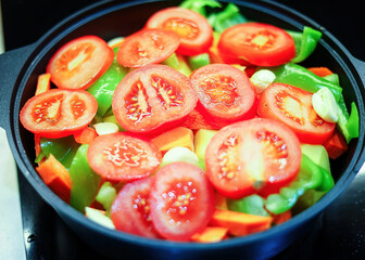 Vegetables and herbs are cooked on the stove in close-up. Meal