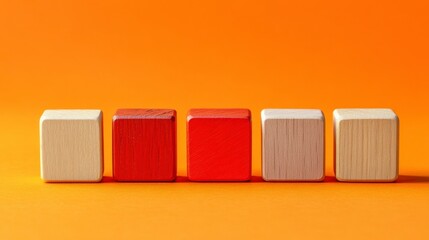 Five wooden blocks in shades of red and beige arranged in a row against a vibrant orange background. The image has a minimalist and simple aesthetic.
