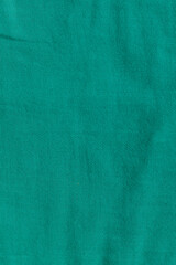 Cotton muslin fabric close-up green color. Muslin texture. Fabric for sewing children's clothes and accessories.