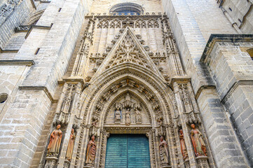 Obraz premium Entrance door in the medieval facade of the cathedral, Seville, Spain