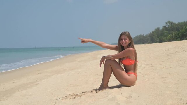 &ldquo;A beautiful blonde woman in an orange bikini walks along a tropical beach, smiling and enjoying the sunny weather. The background features palm trees, rocks, and traditional boats, creating a picture