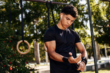 Fototapeta premium Strong young sportsman doing calisthenics at outdoor gym