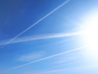 Stunning image of contrails crisscrossing a vibrant blue sky.  Perfect for concepts of travel,...