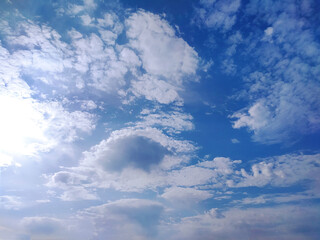 Clear blue sky texture and white fluffy cloud nature background. The sun shines bright in the daytime in summer