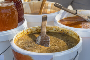 Honey containers with different types of honey at the market, honey trade. Selective focus.