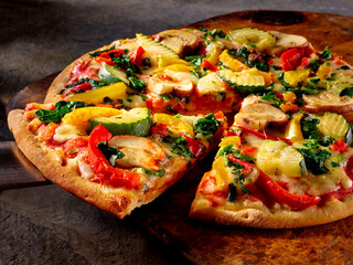 Vegetarische Pizza mit Zucchini Champignons und Paprika mit Slice auf rustikaler Holzplatte, Italien, pizza, vegetarisch, 