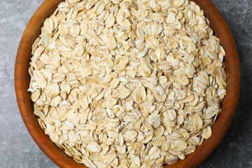 Composition with oatmeal flakes on gray background. Cooking breakfast