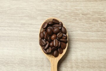 Obraz premium Wooden spoon with coffee beans on wooden background