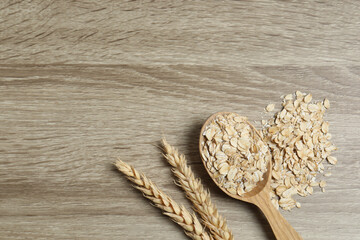 Composition with oatmeal flakes on wooden background. Cooking breakfast