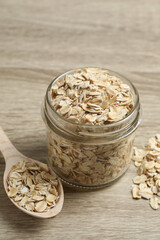 Composition with oatmeal flakes on wooden background. Cooking breakfast