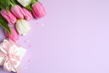 Fototapeta premium Happy Mother's day. Beautiful bouquet of fresh tulips with gift box on a colored background