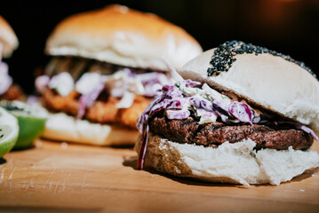 A burger with coleslaw and a lime on the side