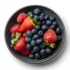 Obraz premium Fresh strawberries, raspberries, and blueberries in a bowl on white background, food photography