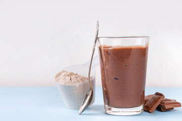 Quick and simple protein pudding. Healthy summer cold dessert. Three glasses with vanilla, chocolate and berry protein pudding, with chocolate slices, fresh strawberry, blueberry, protein powder scoop