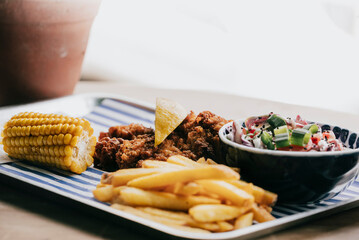 A plate of food with a bowl of coleslaw and a lemon wedge on top of it
