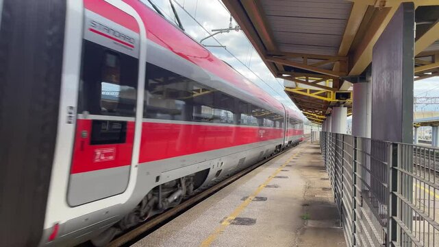 Italy , Florence, March 31st  2025- Frecciarossa Trenitalia Hight speed 300km h train railway view from a station  the faster way to travel in Italy from Milan to Rome. A1 motorway , cars and train