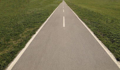 Obraz premium empty long Asphalt road in perspective with blue sky. City urban park. Bicycle asphalt path in the park on a sunny day. mock up template. Belgrade Serbia