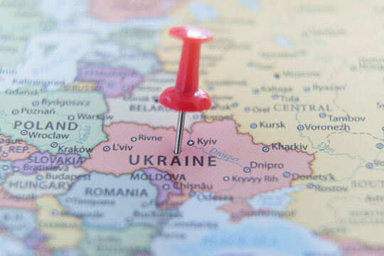 Close-up of a map with a red pushpin marking Ukraine. Travel, geography, and politics concept.