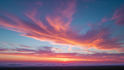 Vibrant sunset illuminating colorful clouds over foggy landscape