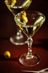 A martini glass with green olives set against a golden bokeh background, creating a festive and luxurious vibe.