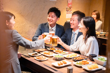 居酒屋で部署のお疲れ様会をするビジネスパーソン