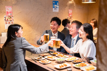 居酒屋で部署のお疲れ様会をするビジネスパーソン