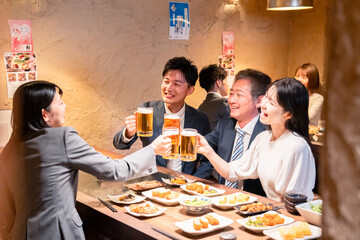 居酒屋で部署のお疲れ様会をするビジネスパーソン