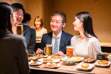 居酒屋で部署のお疲れ様会をするビジネスパーソン