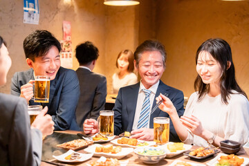 居酒屋で部署のお疲れ様会をするビジネスパーソン