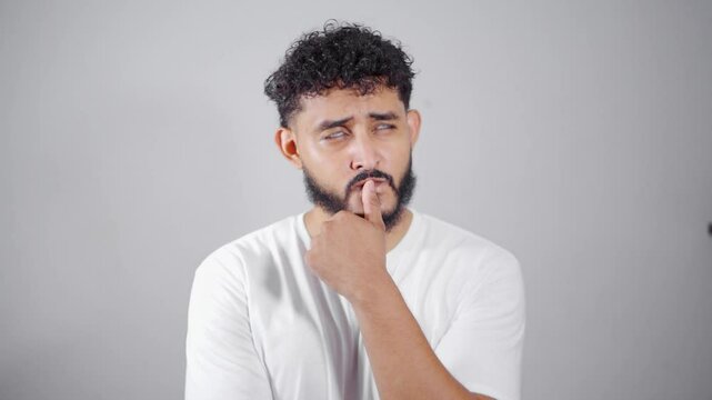 Pensive man making facial expressions on white background